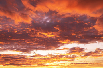 Naklejka na ściany i meble Beautiful red vibrant burning sunset sky with clouds