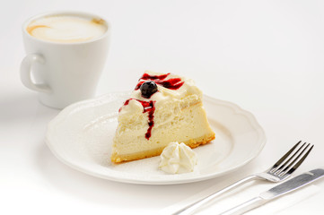 Delicious cheesecake with jam and a cup of cappuccino on a white background