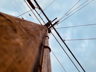 Low angle view of looking up a wooden power line pole