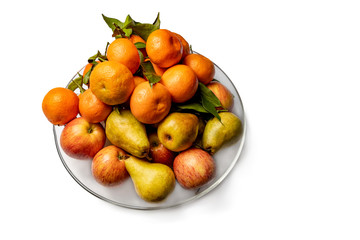 Apples, pears and tangerines in a plate isolated on a white background.