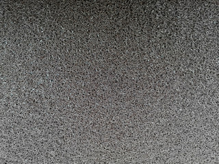 The usual texture of a black carpet with a long pile with durable threads