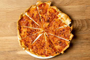 Pizza, mozzarella cheese and tomato, on a wooden background.