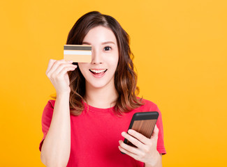 happy young woman holding smart phone and credit card.