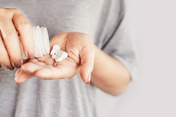 closeup woman hand holding medicine bottle taking overdose pills 