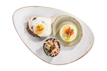 Fried egg with beefsteak, mashed potatoes and pickled cabbage on white plate isolated on white background