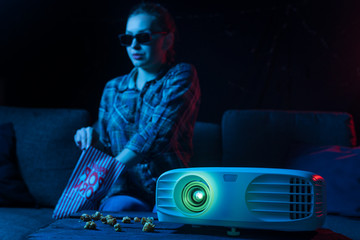 Cheerful viewing of a girl in 3D glasses at a home cinema. Rest and relaxation