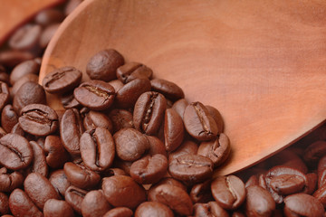 Coffee beans are taken with a wooden spoon to prepare the drink. Close up