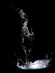 Water with splashes in a glass on a black background