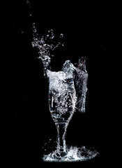 Water with splashes in a glass on a black background