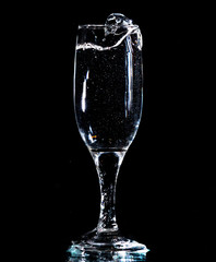 Water with splashes in a glass on a black background