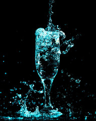blue water with splashes in a glass on a black background