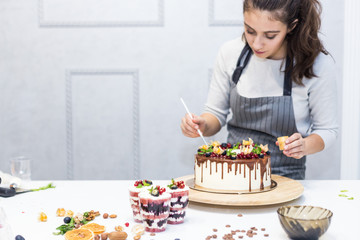 Decoration of the finished dessert. Pastry chef sprinkles confectionery with yellow powder. The...