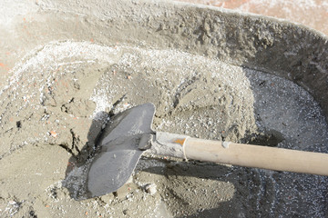 concrete and shovel in barrow at construction site