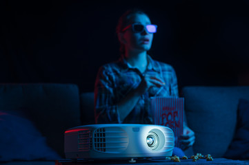 Cheerful viewing of a girl in 3D glasses at a home cinema. Rest and relaxation