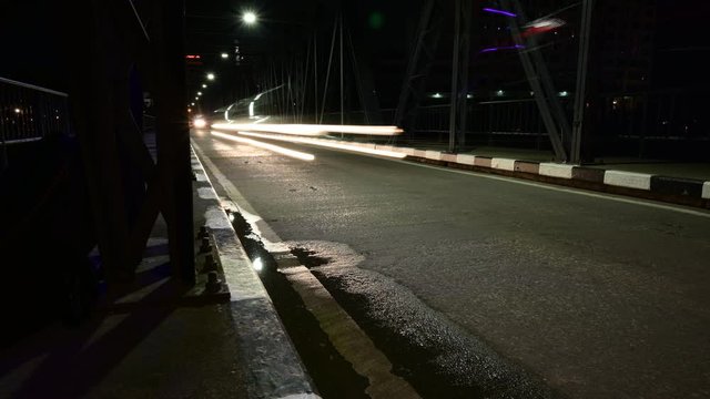 Night timelapse speed light from car across the steel bridge long exposture