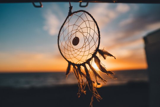 Dreamcatcher hanging on the beach with the beautiful view of sunset in the background - Powered by Adobe