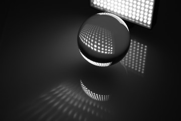 Sfera di vetro trasparente fotografata su sfondo scuro illuminata a led