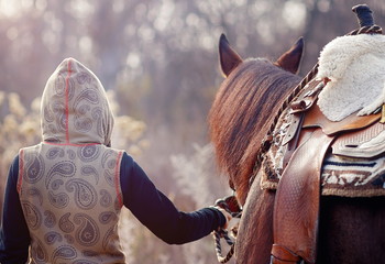 Young beautiful dreadded girl outdoors with her horse.