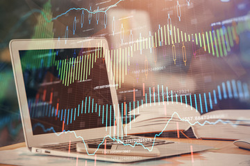 Forex graph hologram on table with computer background. Double exposure. Concept of financial...