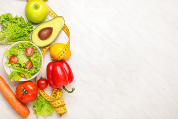Different healthy food with measuring tape on light background. Diet concept