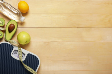 Different healthy food with measuring tape and scales on wooden background. Diet concept