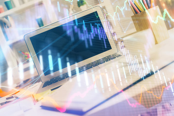 Stock market graph on background with desk and personal computer. Double exposure. Concept of financial analysis.