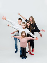 Obraz premium five teenagers with outstretched arms jumping in front of the camera.