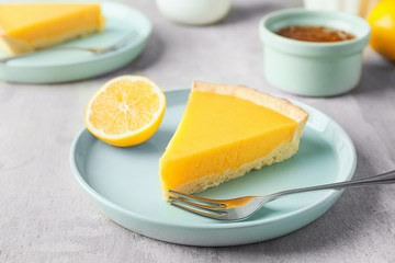 Fototapeta na wymiar Plate with slice of tasty homemade lemon pie on table