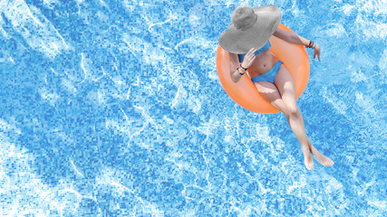 Beautiful woman in hat in swimming pool aerial top view from above, young girl in bikini relaxes...