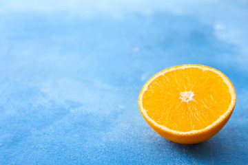 Half of sweet tasty orange on color background
