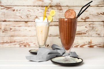 Glasses of tasty milkshakes on table