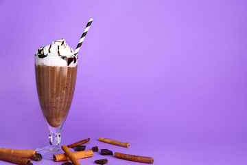 Glass of tasty milkshake on color background