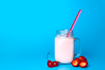 Mason jar of tasty milkshake on color background