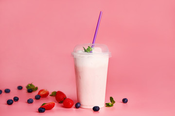 Cup of tasty milkshake on color background