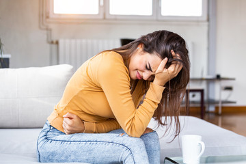 Young sick woman with hands holding pressing her crotch lower abdomen. Medical or gynecological...