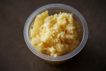Crushed garlic in plastic bowl 