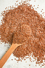 Spoon and flax seeds on white background