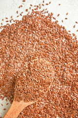Spoon and flax seeds on white background