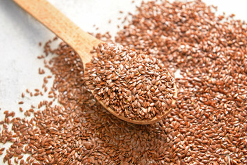 Spoon and flax seeds on white background
