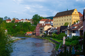 View of traditional czech houses and Vltava river with green trees and vegetation, in Cesky Krumlov, Czech Republic