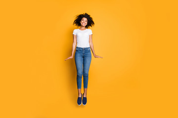 Full length body size photo of cheerful positive cute nice charming girl aspiring up jumping wearing jeans denim isolated vivid color background
