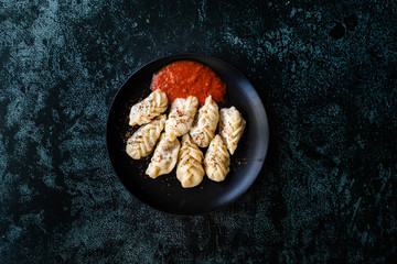 Georgian Dumplings Khinkali with Meat, Tomato Sauce and Spices / Hingel.