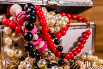 Aluminium case full of different jewelry on wooden table