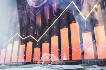 Forex graph with businessman typing on computer in office on background. Concept of analysis. Double exposure.