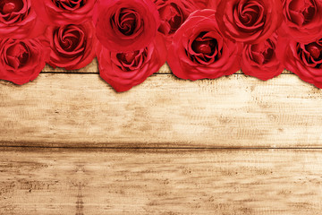 Red roses on wooden table background