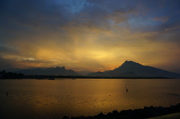  sunset and sunrise on the beach with a mountain backdrop