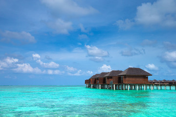 Beautiful tropical Maldives island with beach. Sea with water bungalows