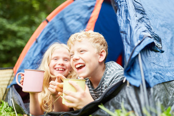 Zwei Kinder schauen aus Zelt beim Zelten