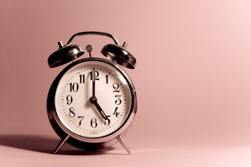 Vintage alarm clock on a solid color background