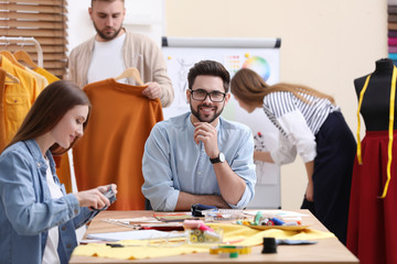 Fashion designers creating new clothes in studio